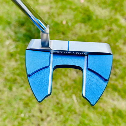 Blue golf putter head with 'Bettinardi' branding on a grass background