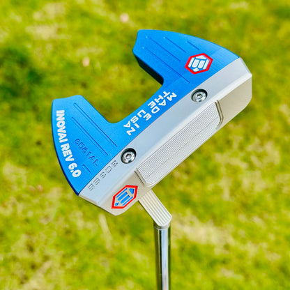 Blue and silver golf putter with 'Made in EU' text on a grass background